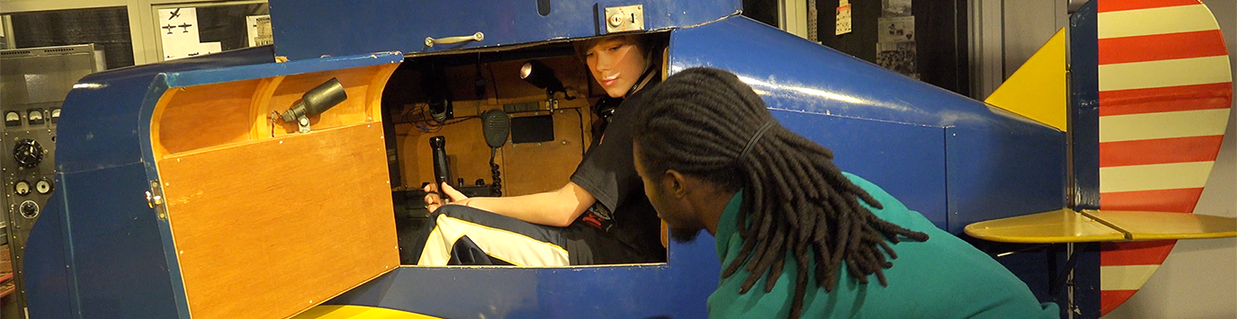 MOST staff member instructs a guest on using the Link Flight Trainer