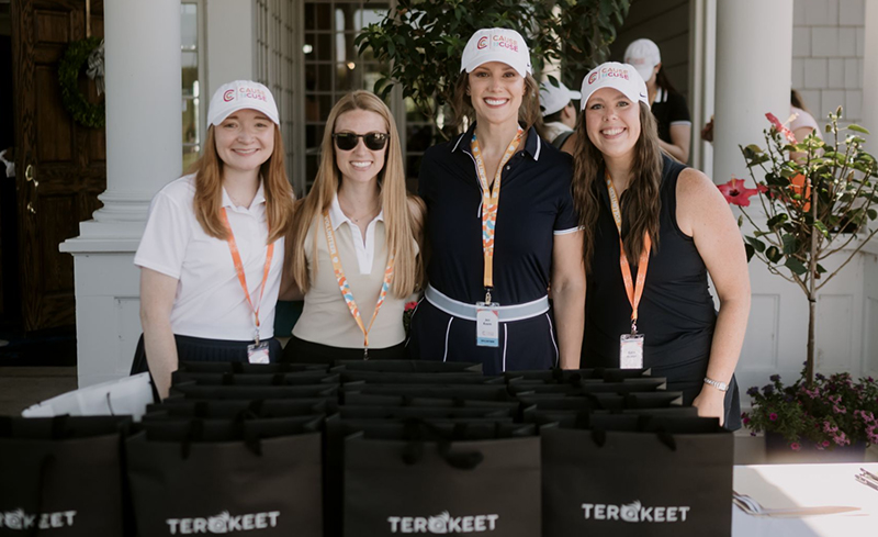 Volunteers from the Terakeet Invitational smiling at the golf tournament registration table